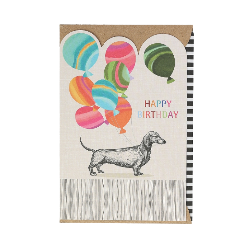 Geburtstagskarte mit einem gezeichneten Dackel, der bunte Ballons am Rücken trägt, daneben der bunte Schriftzug „Happy Birthday“