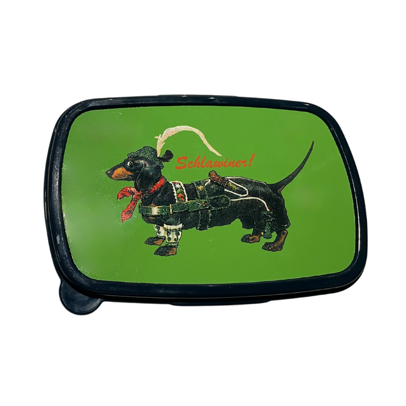 Grüne Brotdose mit einem lustigen Dackel in Lederhose und einer Feder auf dem Kopf, der den bayerischen Charme unterstreicht.