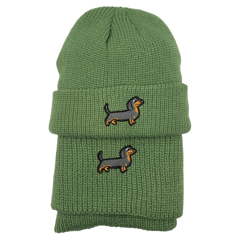 Grünes Strick-Set bestehend aus Mütze und Schal, verziert mit einem gestickten Dackel-Motiv.