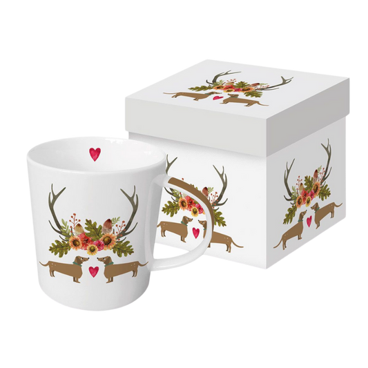Keramikbecher mit lustigem Dackel-Paar Walter und Waltraud in Geweih und floraler Dekoration auf weißem Hintergrund, präsentiert in einer weißen Geschenkbox.