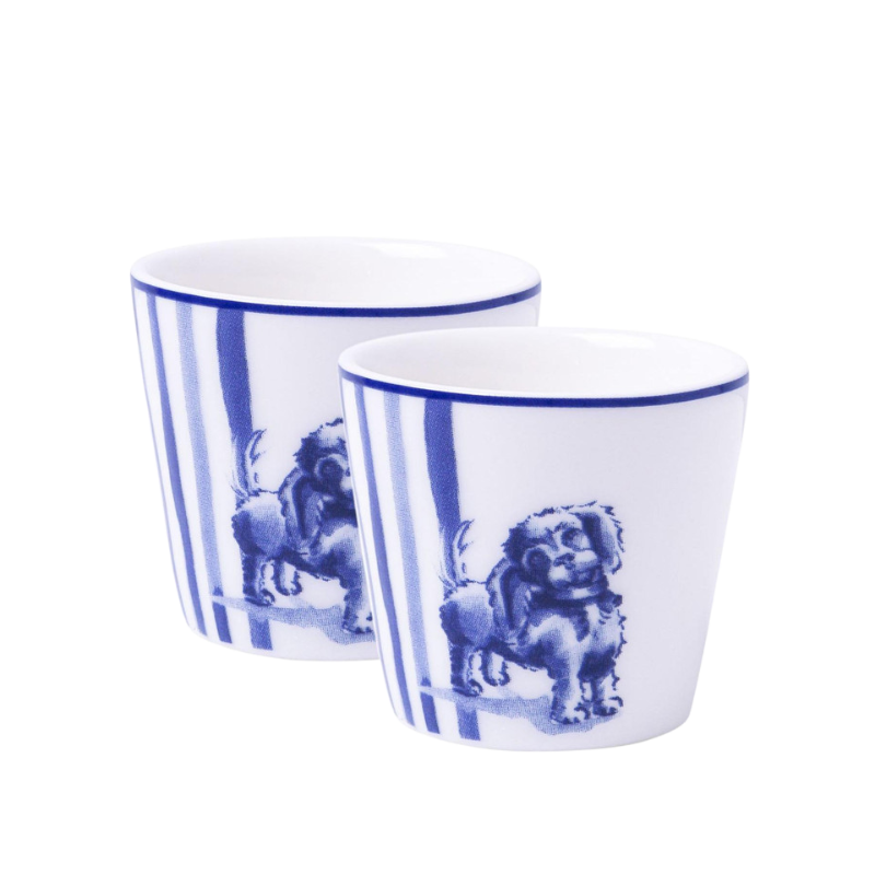 Zwei zylindrische Eierbecher mit senkrechten blauen Streifen und Illustrationen von sitzenden Löwen in einem klassischen blauen Farbton. Diese einzigartigen Eierbecher fügen jedem Frühstückstisch einen Hauch von Erhabenheit hinzu.