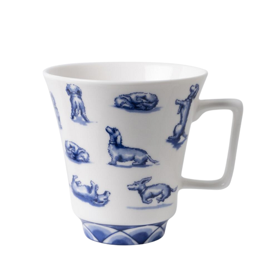 Weiße Teetasse mit blauen Abbildungen von Dackeln in verschiedenen Posen, inklusive rennender und ruhender Dackel, mit einem blau gestreiften Sockel und dekorativen Ornamenten am Rand.