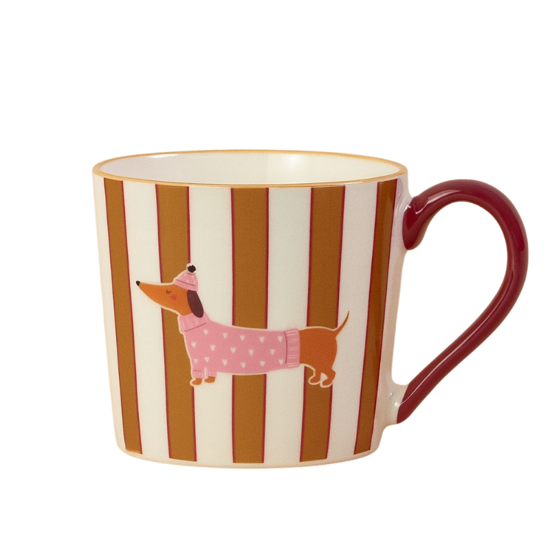 Keramiktasse mit vertikalen rot-braunen Streifen und einem Aufdruck eines Dackels im rosa Pullover und Mütze; roter Henkel.