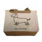 Naturfarbene Stofftasche mit braunem Juteboden, schwarzem Dackel-Umriss und dem Schriftzug „WE LOVE DOGS“ auf der Vorderseite.