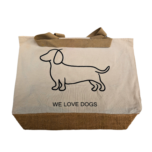 Naturfarbene Stofftasche mit braunem Juteboden, schwarzem Dackel-Umriss und dem Schriftzug „WE LOVE DOGS“ auf der Vorderseite.