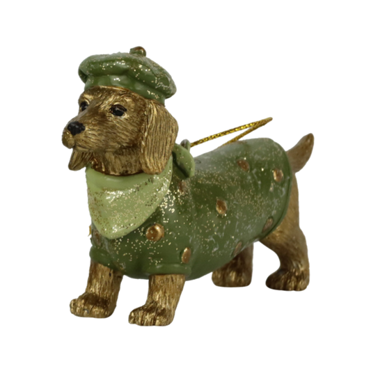 Goldbrauner Dackel als Weihnachtsfigur, gekleidet in grünem Mantel mit goldenen Punkten, passender Mütze und Halstuch