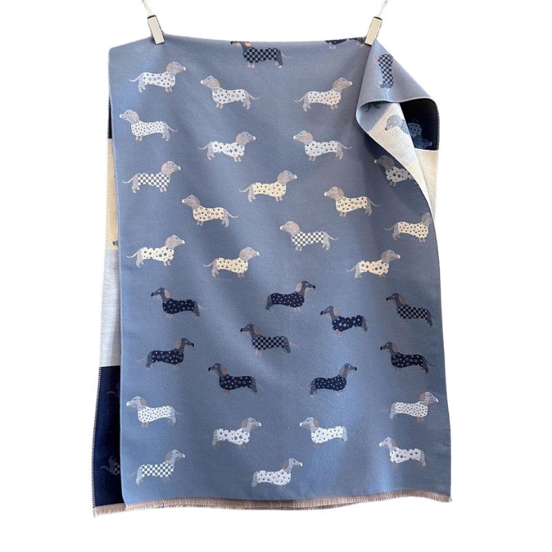 Wendeschal mit Dackel-Muster in zwei Farbvarianten – Blau und Beige – mit liebevollen Dackelmotiven, weich und kuschelig, ideal für Herbst und Winter.