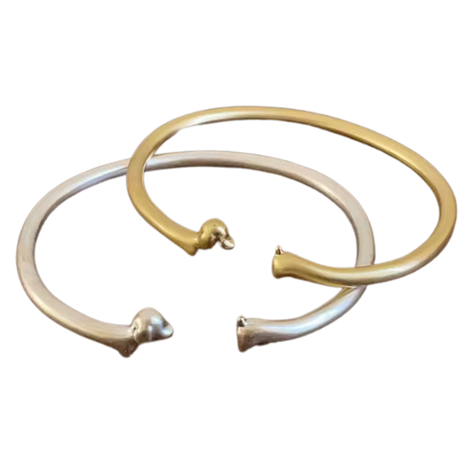 Zwei offene Armreifen in Gold und Silber mit Dackelkopf und -schwanz als Enden