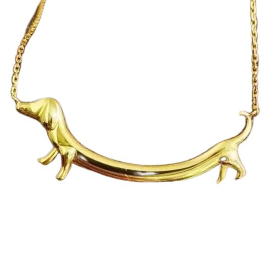 Goldfarbene Halskette mit einem langgezogenen Dackel-Anhänger, getragen am Hals.
