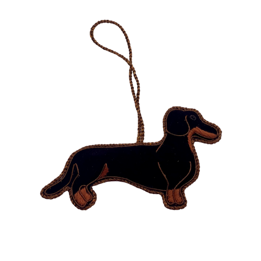 Weihnachtsanhänger eines schwarz-goldenen Dackels aus Stoff mit Stickerei und goldener Aufhängung.