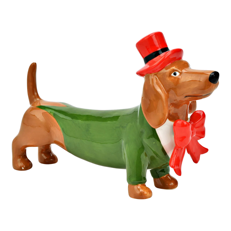 Keramikfigur eines Dackels in grünem Frack mit roter Fliege und rotem Zylinderhut, in aufrechter Haltung mit vornehmem Blick.