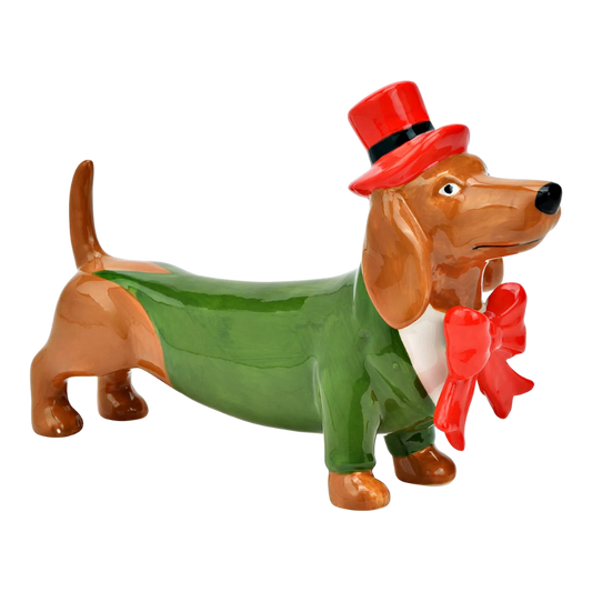 Keramikfigur eines Dackels in grünem Frack mit roter Fliege und rotem Zylinderhut, in aufrechter Haltung mit vornehmem Blick.