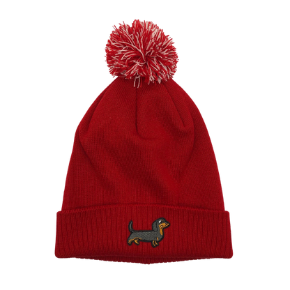 Strickmütze mit Bommel und gesticktem Dackelmotiv auf dem Umschlag, erhältlich in neun verschiedenen Farben.