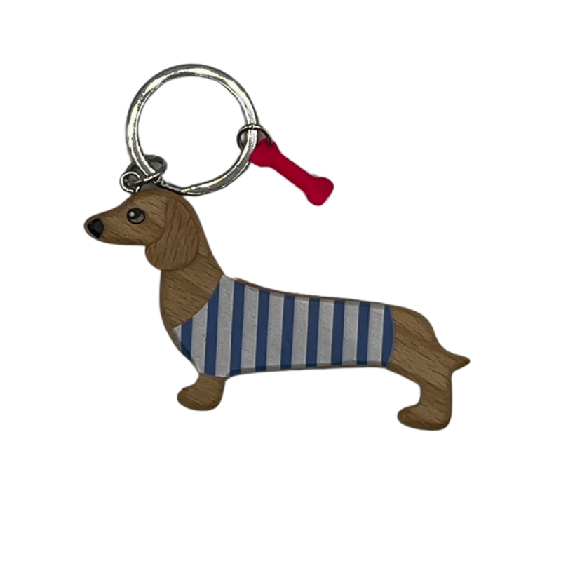 Schlüsselanhänger aus Holz in Form eines Dackels mit blau-weiß gestreiftem Pullover und kleinem pinkem Knochen-Anhänger am Schlüsselring.