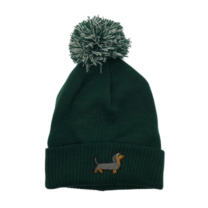 Strickmütze mit Bommel und gesticktem Dackelmotiv auf dem Umschlag, erhältlich in neun verschiedenen Farben.