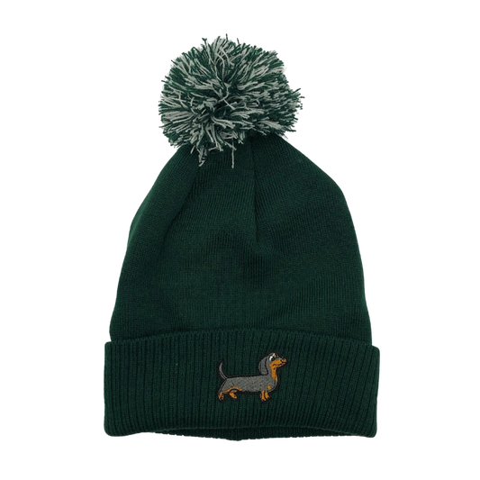 Strickmütze mit Bommel und gesticktem Dackelmotiv auf dem Umschlag, erhältlich in neun verschiedenen Farben.