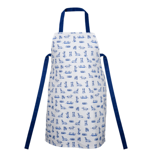 Küchenschürze mit zahlreichen blauen Dackel-Motiven auf weißem Grund, versehen mit blauen Bändern und einer Nackenschlaufe.