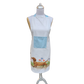 Weiße Küchenschürze mit hellblauer Tasche und Aquarell-Illustration eines braunen Dackels, der durch eine Blumenwiese läuft; getragen auf einer Schneiderpuppe
