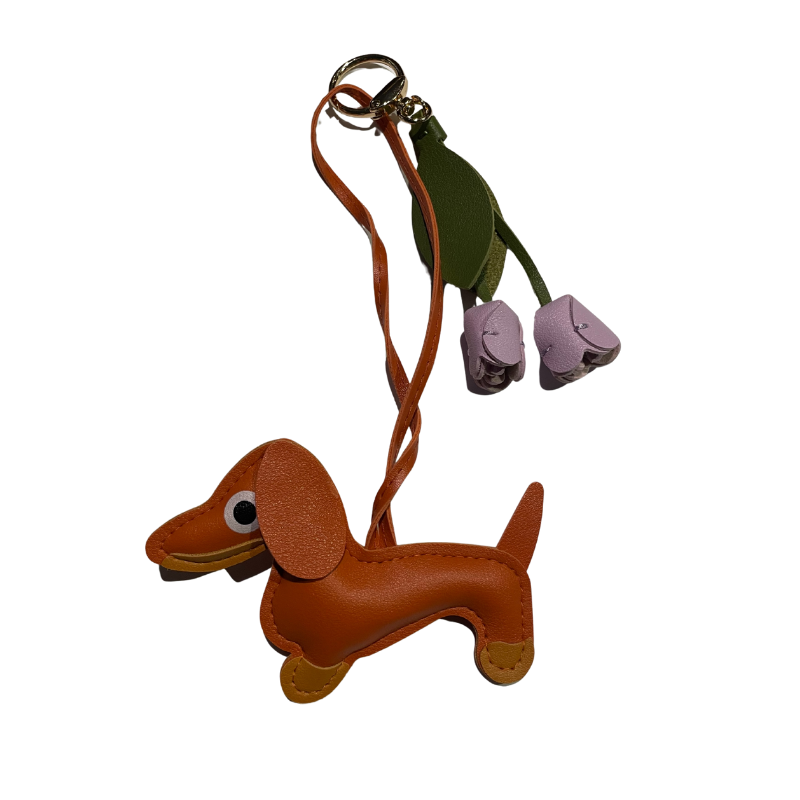 Schlüsselanhänger in Dackelform aus Kunstleder in hellbraun mit zwei lila Lederblüten als Dekoration