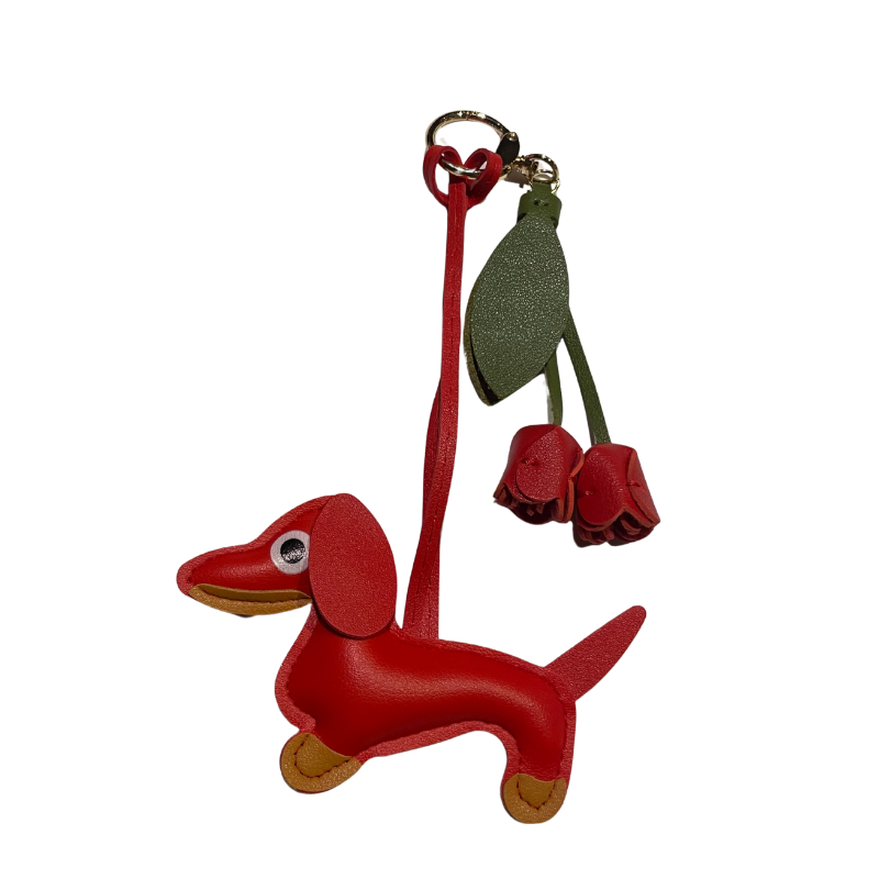 Roter Dackel-Schlüsselanhänger aus Kunstleder mit zwei roten Lederblüten und grünem Blattanhänger.