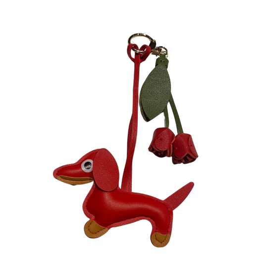 Roter Dackel-Schlüsselanhänger aus Kunstleder mit zwei roten Lederblüten und grünem Blattanhänger.