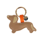Schlüsselanhänger in Dackelform aus beigefarbenem Leder mit goldenen Details an Ohr und Rute, befestigt an einem goldenen Schlüsselring mit orangener Schlaufe und rundem Anhänger.