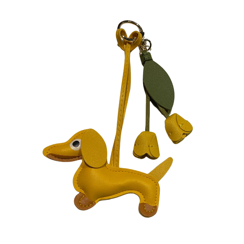 Gelber Dackel-Schlüsselanhänger aus Kunstleder mit zwei gelben Lederblüten und grünem Blattanhänger