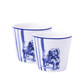Zwei zylindrische Eierbecher mit senkrechten blauen Streifen und Illustrationen von sitzenden Löwen in einem klassischen blauen Farbton. Diese einzigartigen Eierbecher fügen jedem Frühstückstisch einen Hauch von Erhabenheit hinzu.